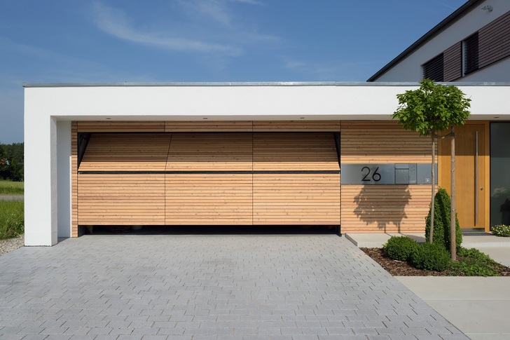 Durch das zweigeteilte Kipptor können auch Geländewagen in der Garage parken, obwohl das Tor nicht nach außen ausschwenkt.