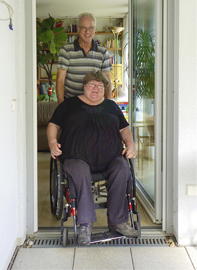 
Brigitte Seiferheld freut sich: „Über die Magnet-Doppeldichtung komme ich mit meiner Tetraplegie völlig selbstständig zurecht!“ Das Ehepaar Brigitte und Frieder Seiferheld konnten bereits über 21 Jahre Erfahrungen mit Magnet-Nullschwellen sammeln: „Wir haben 1996 in unsere vorherige Wohnung in Freiberg am Neckar die schwellenfreie Magnet-Doppeldichtung zur Gartenterrasse einbauen lassen und sie funktioniert bis heute ausgezeichnet. Auch in der neuen Wohnung in Ludwigsburg haben 2010 unsere Terrassentüren diese Nullschwelle erhalten“, berichtet Frieder Seiferheld. Die Dichtung sei absolut dicht, er habe die Tür sogar mit einem Gartenschlauch gereinigt und es sei kein Tropfen Wasser durchgedrungen. 



