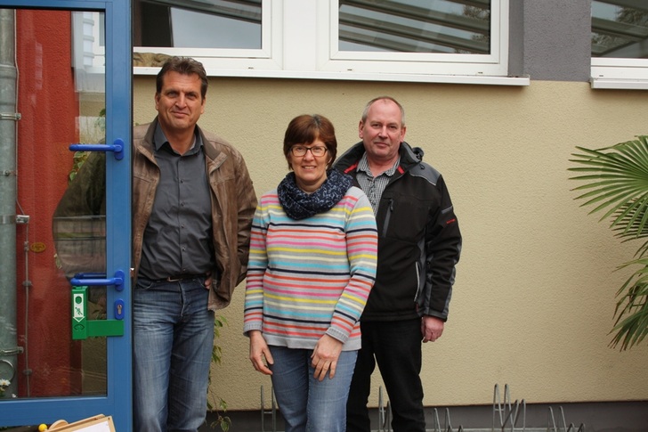 Holger Wunsch (v. l.), Wilka Fachberater Metallbau, Kindergartenleiterin Rita Lunden und Joachim Frey, Brandschutzbeauftragter der Gemeinde an der umgerüsteten Kindergartentür.