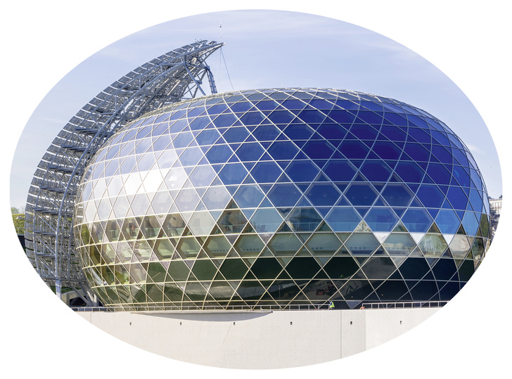 

Die wabenförmigen Wände wurden aus 1700 individuell gewellten Nadelholzstücken zusammengefügt und diese Geometrie prägt das Innere des „Auditoriums“ mit seiner Bühne im Zentrum und den umlaufenden Rängen.