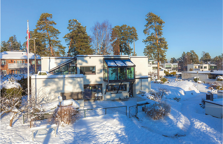 
Der Wintergarten ist vor das 1. OG des Haupthauses gesetzt; die Lasten werden über schräge Stützen auf die Grundmauer abgetragen (System Schüco CMC 50 mit SageGlass® Blau im Dachbereich).



