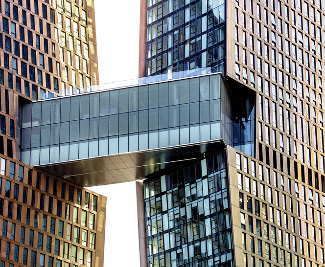 
Die Skybridge, die dreistöckige Verbindungsbrücke, hüllt sich in metallisch schimmerndes Glas.



