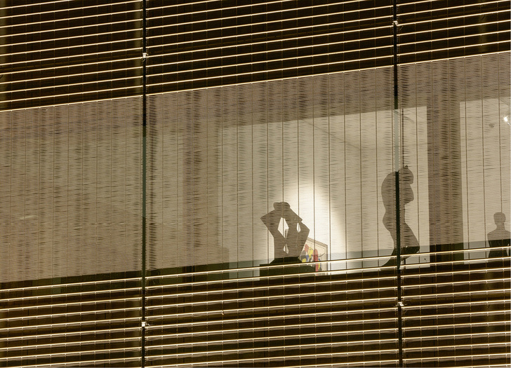 <p>
</p>

<p>
Die Gebäudehülle besteht u. a. aus großflächigen Verglasungen, vor die eine zweite Hülle aus einem bronzefarbenen Metallnetz gesetzt wurde.
</p> - © Foto: Constantin Meyer Photographie

