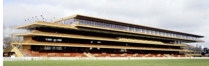 



Durch die offenen, leicht versetzten und doppelt geneigten Etagen erinnert die Form der Haupttribüne an ein galoppierendes Rennpferd.
