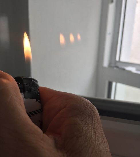 Mit einem einfachen Feuerzeug lässt sich die Zahl der Scheiben und Beschichtungen in einem Fenster ermitteln (das geht natürlich auch mit einer Kerze...) - © Daniel Mund / GLASWELT
