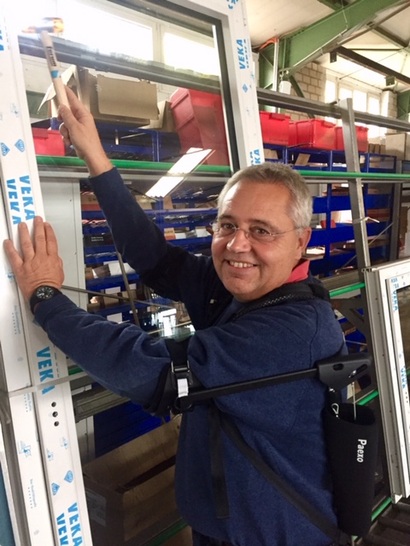 Dr. Frank Walter testet das Exoskelett an der Glasstation - © Walter Fenster + Türen
