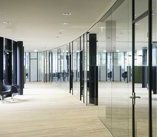 



Die äußere Gebäudeform sowie die Innenräume sind geprägt von oval verlaufenden Wandflächen. Im Gebäude kommt das flexible Längle Glastrennwand-System AL-Office XL zum Einsatz.
