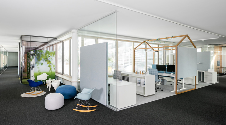 In Open-Space-Bürowelten gehen die Zonen für Arbeit, Meeting und Rekreation ineinander über. Im Bild schirmen Glaselemente im System fecoplan einen Arbeitsbereich von einer Sitzgruppe ab.
