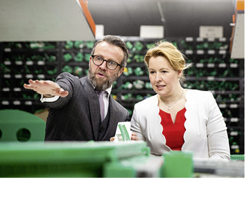 



Stefan Schwanekamp erläutert Dr. Giffey den Biegeprozess von Kunststoffprofilen.
