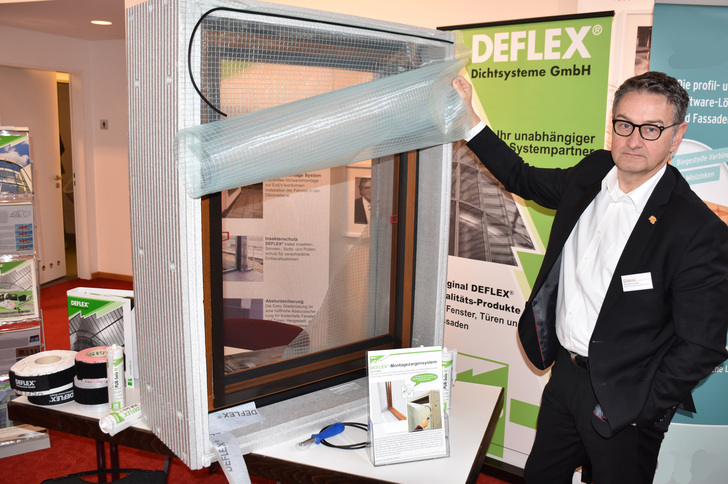gw19-05E15-01 Michael Loogen, Leiter Technische Anwendungsberatung bei Deflex demonstriert die Funktionsweise des Rohbauschutzes: Hochwertige Fensterprodukte werden erst nach Ende der Rohbauphase montiert, in der Rohbauphase übernimmt eine Plane den Wetterschutz.