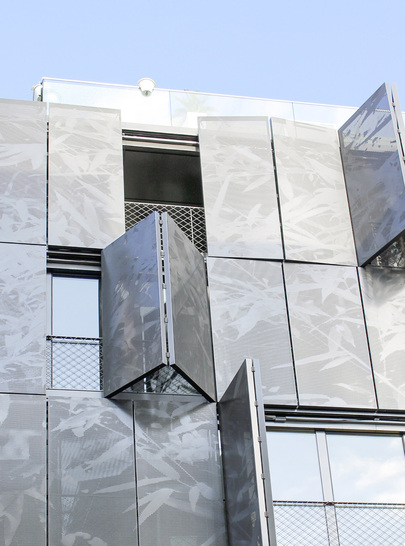 Erst mit der Öffnung der Faltläden kommt Bewegung und damit Leben in die harte Fassadenstruktur.