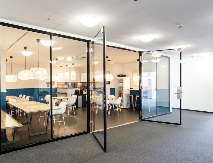 Die neue rahmenlose, zweiflügelige Ganzglastür 30 von Promat kommt ohne Riegel und Profile aus.