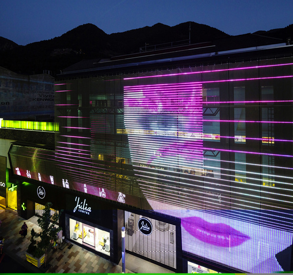 Transparente Medienfassade Imagic Weave in Andorra: Die bewegten Bilder von Videos scheinen unmittelbar vor der Fassade zu schweben.