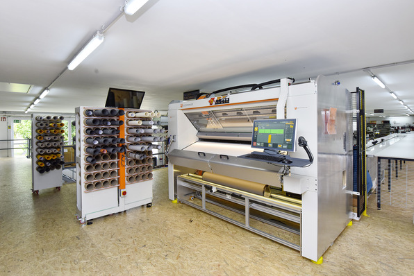 Bewegung auf kleinstem Raum. Mit der computergesteuerte Zuschneidemaschine ScreenCut für Markisenstoffe hat man die Konfektion optimiert und neue Platzreserven in einer definierten Raumebene geschaffen. 