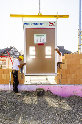 Einsetzen des Fenster-Komplettelements in teilweise aufgemauerte Außenwände mittels Kran