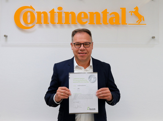 Rainer Irouschek, Leiter des Exteriorbereichs für Oberflächenmaterialien bei Continental, mit der Urkunde über die Premium-Partnerschaft.