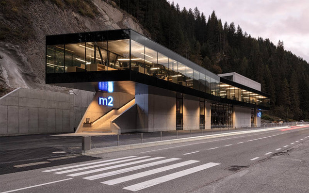 Beim Bürogebäude der m2 Railgroup in La Valle erstreckt sich eine Glasfront über die gesamte Länge des auskragenden Obergeschosses 