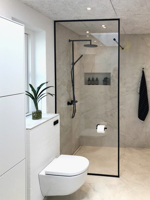 Hier eine gläserne Duschtrennwand von DSG Industri A/S. Hierfür und fü﻿r Dusch­türen ­werden spezielle ­Gläser mit und ohne wasser­abweisende Nano-­Beschichtung angeboten