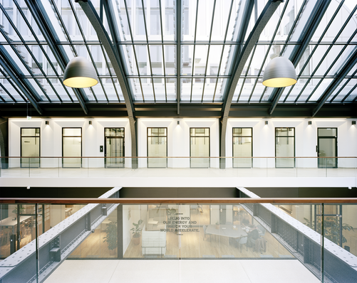 In der zentralen Halle mit ihrer historischen Stahl­konstruktion erlauben die transparenten Brandschutz­elemente von Pilkington den Blick in die an­grenzenden Büro- und Besprechungsräume.