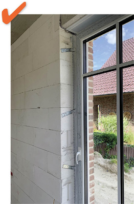 Richtig: Sehr gut ist hier zu erkennen, wie die Montagekonsolen der in der Dämmebene sitzenden Fenstertür im Mauerwerk befestigt sind und somit für einen sicheren Sitz des Elements sorgen.
