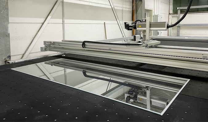 Das Bearbeitungsmodul der Anlage bei Schüt-Duis: Ein ­geführter Laser entfernt am Rand der ­formatierten Glas­scheiben die über Strom  ­ heizende Metall­oxidschicht und ­ermöglicht so eine ­wirtschaftliche serielle Fertigung von Isolierglasheizscheiben.