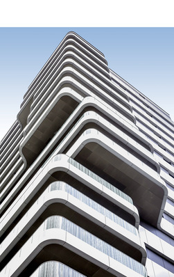 Das Wohnhochhaus fällt durch seine organische Form und durch die geschwungenen ­Balkonbrüstungen auf.