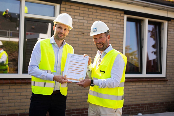 Jelmer Bijlsma von profine Niederlande überreicht das Nachweis-Zerti-fikat "bio-attributed PVC by Kömmerling" für das Projekt in Steenwijk an Freddy van der Werff, CEO des Fensterherstellers Kumij.