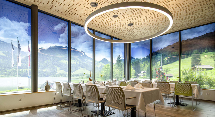 Panoramasaal der Hostellerie am Schwarzsee mit dynamischem Schaltglas Harmony für optimale Lichtverhältnisse und freie Aussicht. 
Oben im Bild sind man eine partielle ­Tönung der Gläser, die dem Bedarf angepasst werden kann