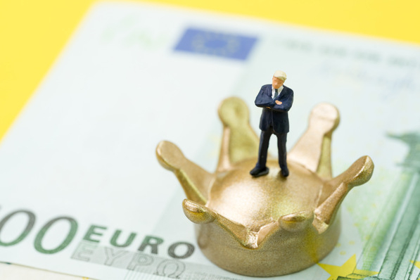 Miniature businessman standing on golden crown on Euro banknotes money using as king or winner of Europe economy, brexit or financial success.