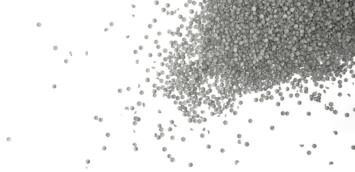 Graue Linsen aus PVC-Rezyklat, die bei Schüco in der Kunststoff-Profilproduktion in Weißenfels eingesetzt werden. Durch den Rezyklat-Einsatz reduziert sich der CO2e-Eintrag der Profile.