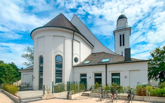 Die ehemalige Kirche ist mit ­verschiedenen Fensterformen in Beton­grau ausgestattet – darunter Bau­elemente mit aufge­koppeltem Rund­bogenfenster, Pfosten-Riegel-­Konstruktionen sowie ein Rundfenster.