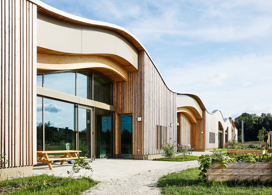 Das geschwungene, begrünte Dach schmiegt sich perfekt in die Auenlandschaft ein.