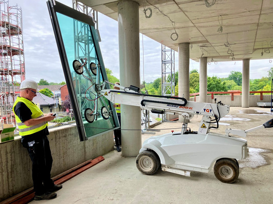 Millimeterangelegenheit: Mit Verfahr- und Hebegeräten erfolgt das Einbringen der spektakulären Feldhaus Elemente in den Baukörper.