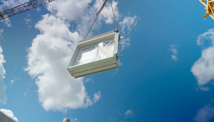 Die Windowment-Elemente mit Fenster von ­Gugelfuss schweben über den Kran ins Haus.