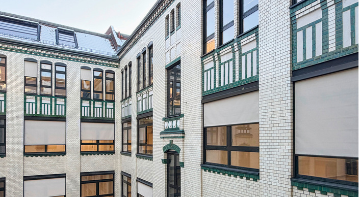 Die historisch geflieste Innenhoffassade durfte nicht beschädigt werden, ebenso wenig die Sandsteinfassade zur Straße. Befestigungen waren ausschließlich an den bauseitigen Aluminiumfenstern zulässig.