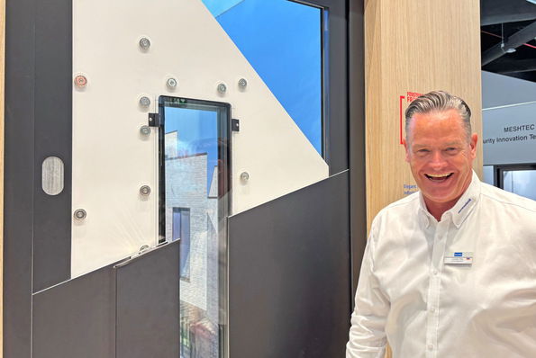 Deceuninck-Deutschland GF Carsten Otte präsentiert auf der Messe die Haustür mit magnetischer Deckschale.