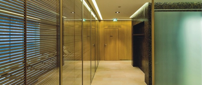 Für innen und außen: Sicht- und Sonnenschutz mit Holzeinlage im ­Scheibenzwischenraum lassen sich mit Okawood umsetzen.