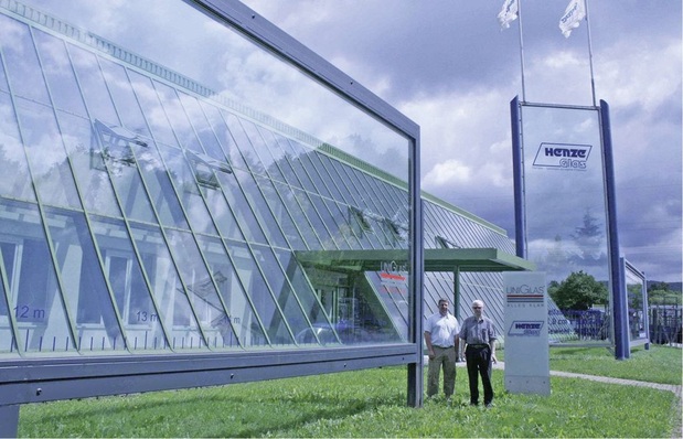 Dietmar Henze und Matthias Zander vor der Halle. Im Hintergrund ist eine 9-Meter-Scheibe zu sehen, links vorne steht das größte 3-fach-Isolierglas der Welt mit seinen 18 Metern Länge und einem Gewicht von fast 4,5 Tonnen.