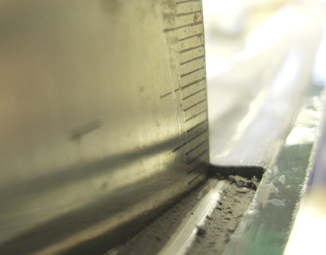 



Bild 1: Blick auf die versiegelte Kante einer Isolierglasscheibe. Ein mit Versatz positionierter Abstandhalterrahmen lässt nicht mehr ausreichend Raum (< 2 mm) für die Sekundärversiegelung am Abstandhalterrücken. Ähnliches kann passieren, wenn die Rahmen nicht exakt rechtwinklig gebogen sind und nach außen ausbauchen.
