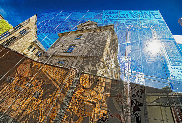 



Das gläserne Fassadenbild zeigt Szenen der friedlichen Revolution in der DDR im Stil eines Comic-Romans. Die Motive basieren auf realen Fotos aus Archiven des Freistaats Sachsen von 1989, die der Hamburger Comic-Künstler Simon Schwartz künstlerisch verfremdete.
