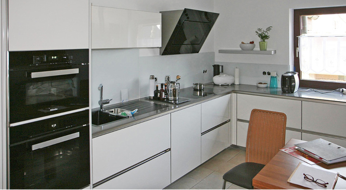 
01: Ansicht der gelieferten und eingebauten Glasscheiben an der Küchenwand unter den Hängeschränken.
