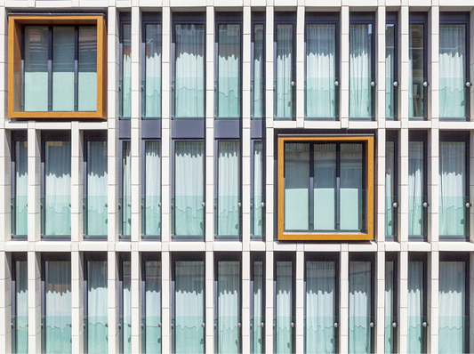 
Die Fassade besitzt fünf große, farbige Rahmen aus Holz, die einen Blickfang in der stark strukturierten Gebäudehülle darstellen.



