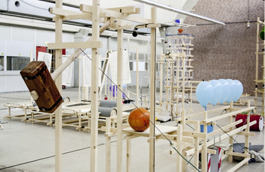 



Bei „Melvin the Machine“ löst das Klingeln eines Weckers eine Kette von Ereignissen aus, die Regenschirme, Papierwindmühlen öffnet oder u. a. ein Feuer legt.
