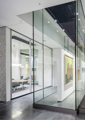 



Die geklebten Vitrinen aus Verbundsicherheitglas sind aus 2 × 12 mm TVG gefertigt und 5,50 m hoch und mittels einer speziellen Konstruktion am Dachtragwerk aufgehängt.
