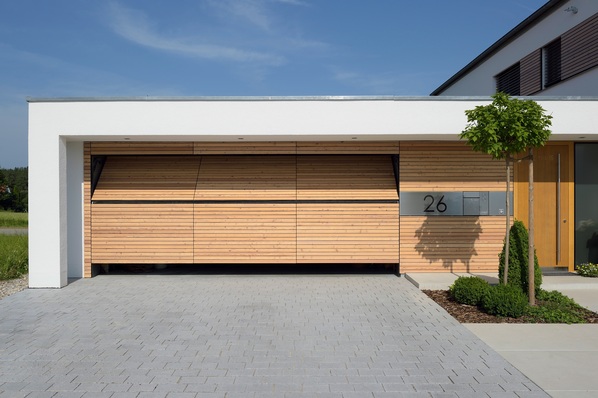 Durch das zweigeteilte Kipptor können auch Geländewagen in der Garage parken, obwohl das Tor nicht nach außen ausschwenkt.