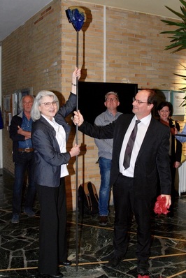 Schulleiterin A.Häring-Heckelmann überreicht ihrem französischen Kollegen A.Bromont ein gläsernes Gastgeschenk.