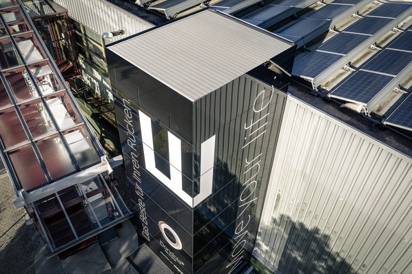 Der 10m hohe Aufzugsturm aus schwarzen, opaken Glaselementen sticht ins Auge. Die gläserne Hülle stammt vom Fassadenspezialisten iconic skin.