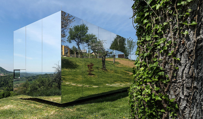 Inmitten des slowenisch-österreichischen Grenzgebiets entfaltet die spiegelnde Fassade der Casa invisibile ihre spektakuläre Wirkung.